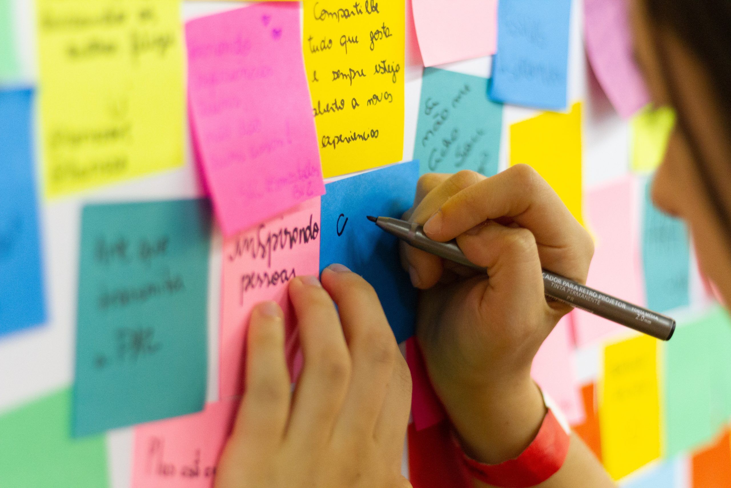 person-writing-on-pink-sticky-notes-3854816